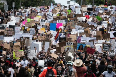 Large group of people filling street with protest signs