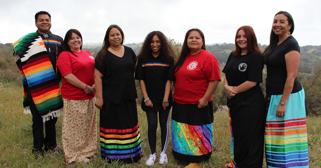 Members from the Strong Hearted Native Women's Coalition standing shoulder to shoulder and smiling for the camera. 