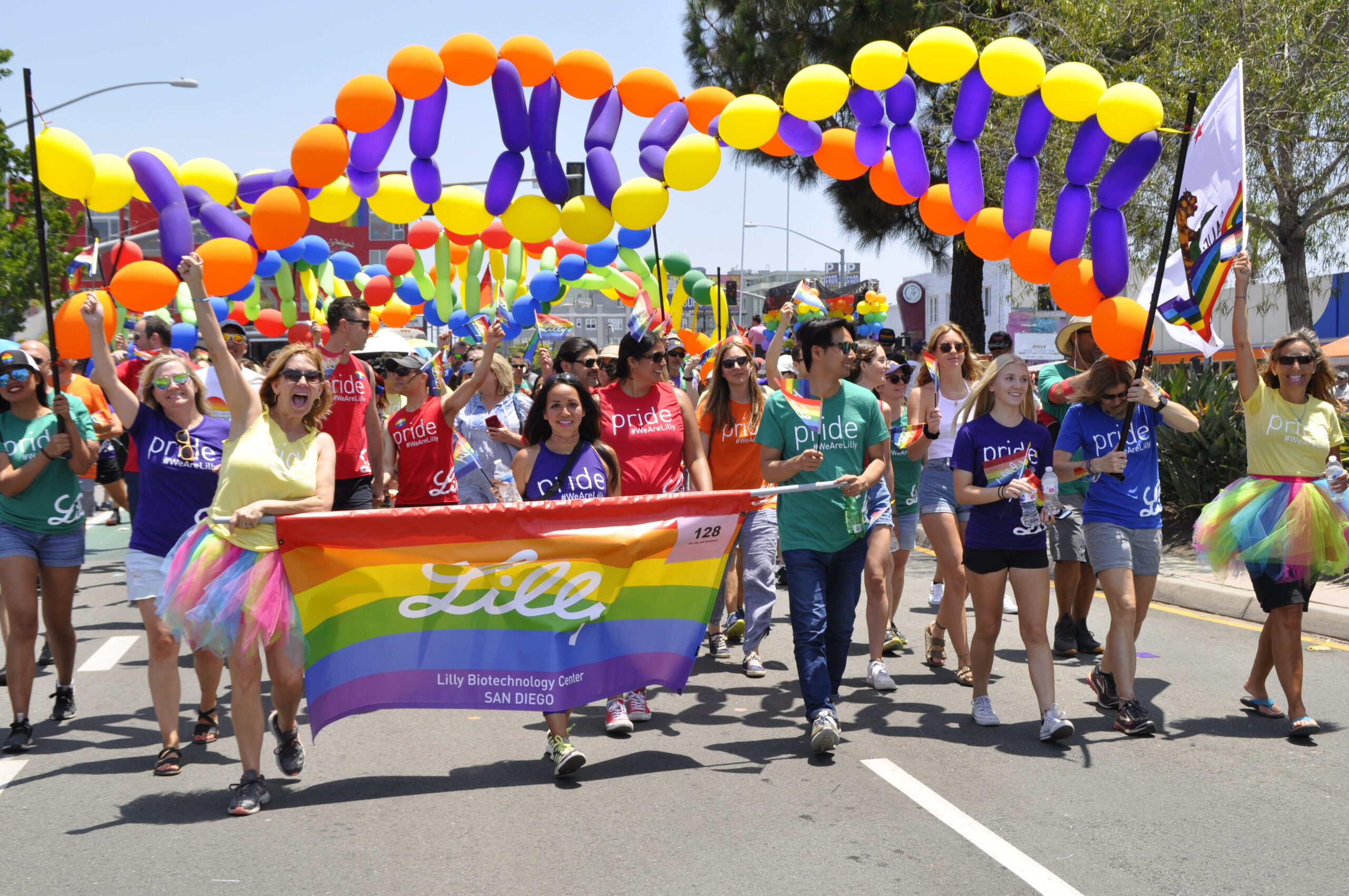 Lilly Parade Contingent walking with rainbow sign and DNA balloons