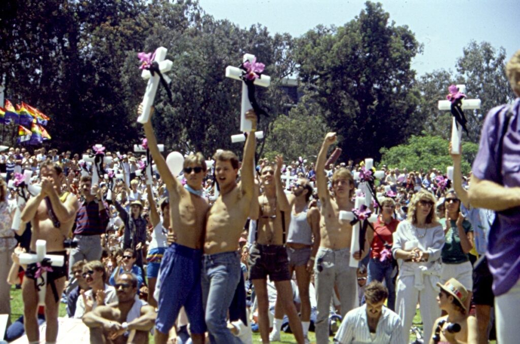 Vintage picture with a large group of people holding white crosses with pink flowers