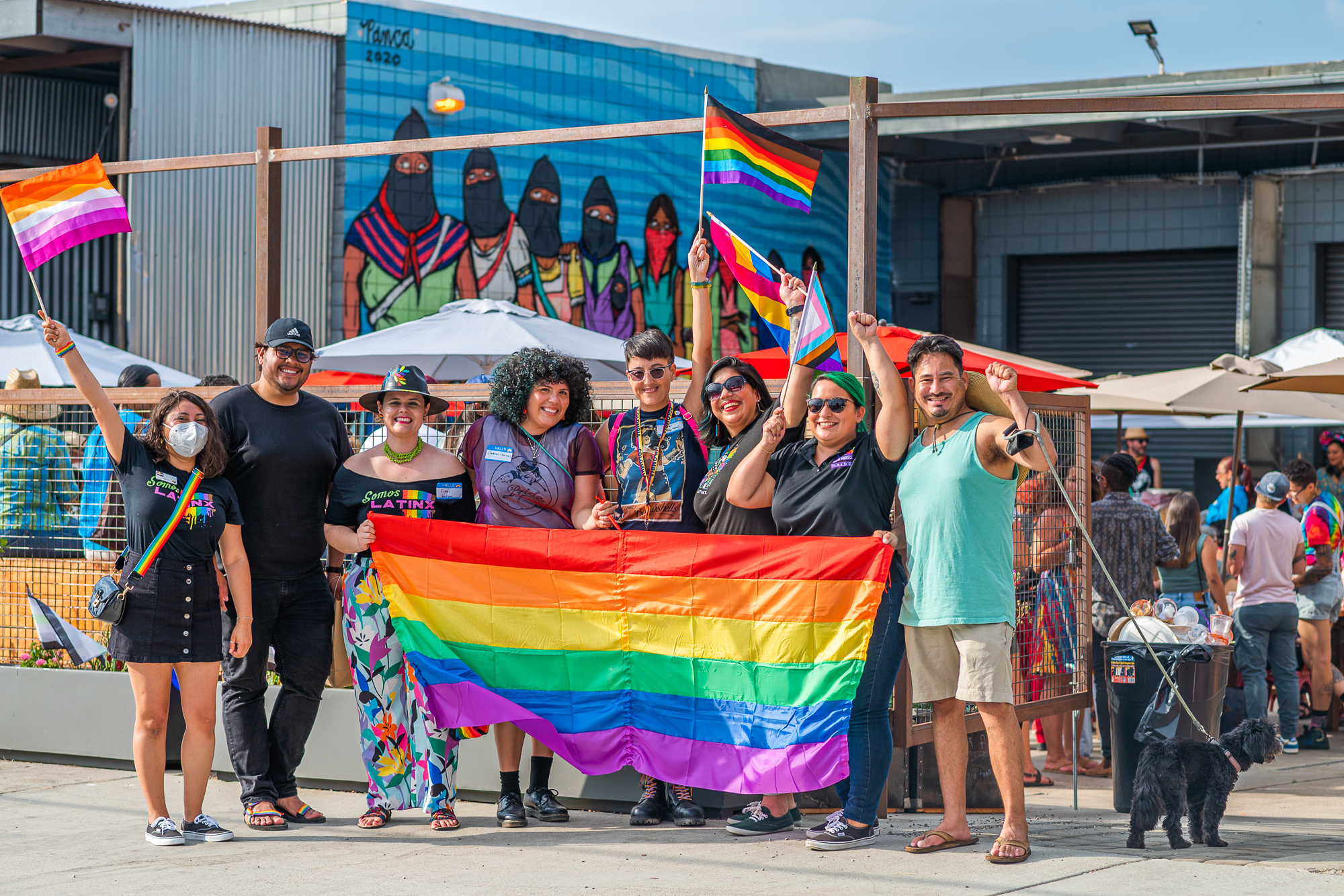 Latine Pride attendees holding pride flag